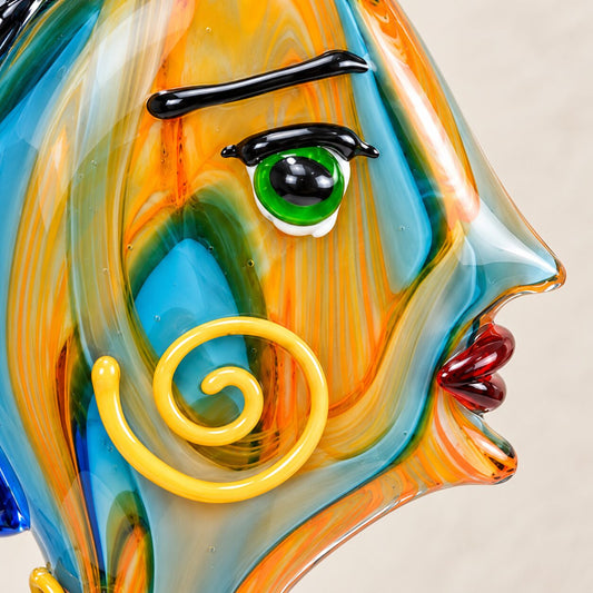 Visage féminin stylisé en verre soufflé bleu cobalt, détail de l'œil et du sourcil