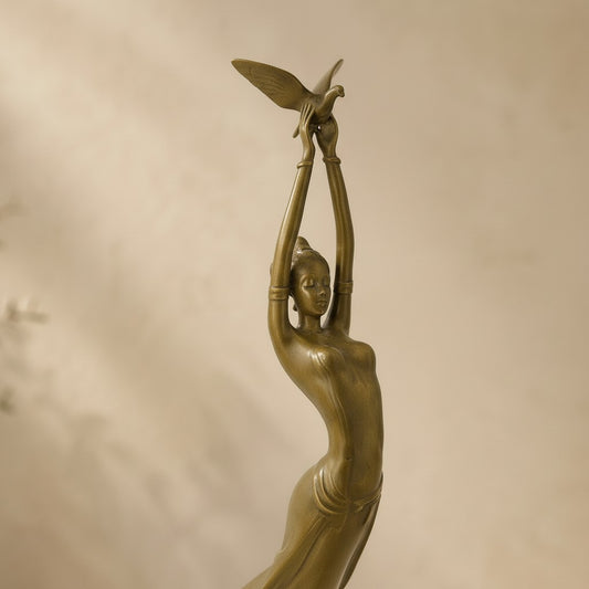 Sculpture en bronze doré style Art Déco représentant une femme élancée tenant une colombe