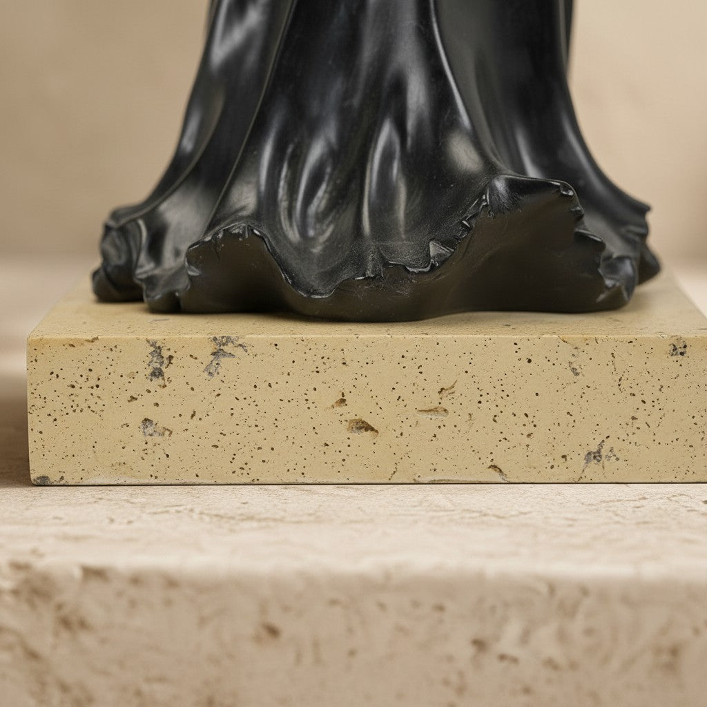 Socle rectangulaire en pierre crème sous une sculpture en bronze représentant la robe noire de la Mort