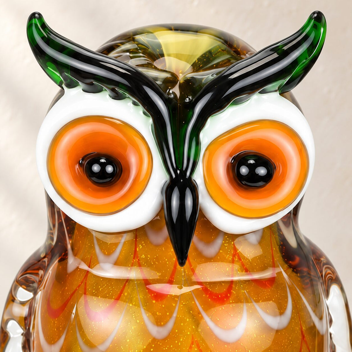 Hibou en verre soufflé aux tons ambrés, détail du visage et des yeux