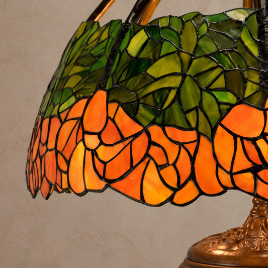 Lampe de style Tiffany aux roses orangées et feuillage vert, gros plan bord