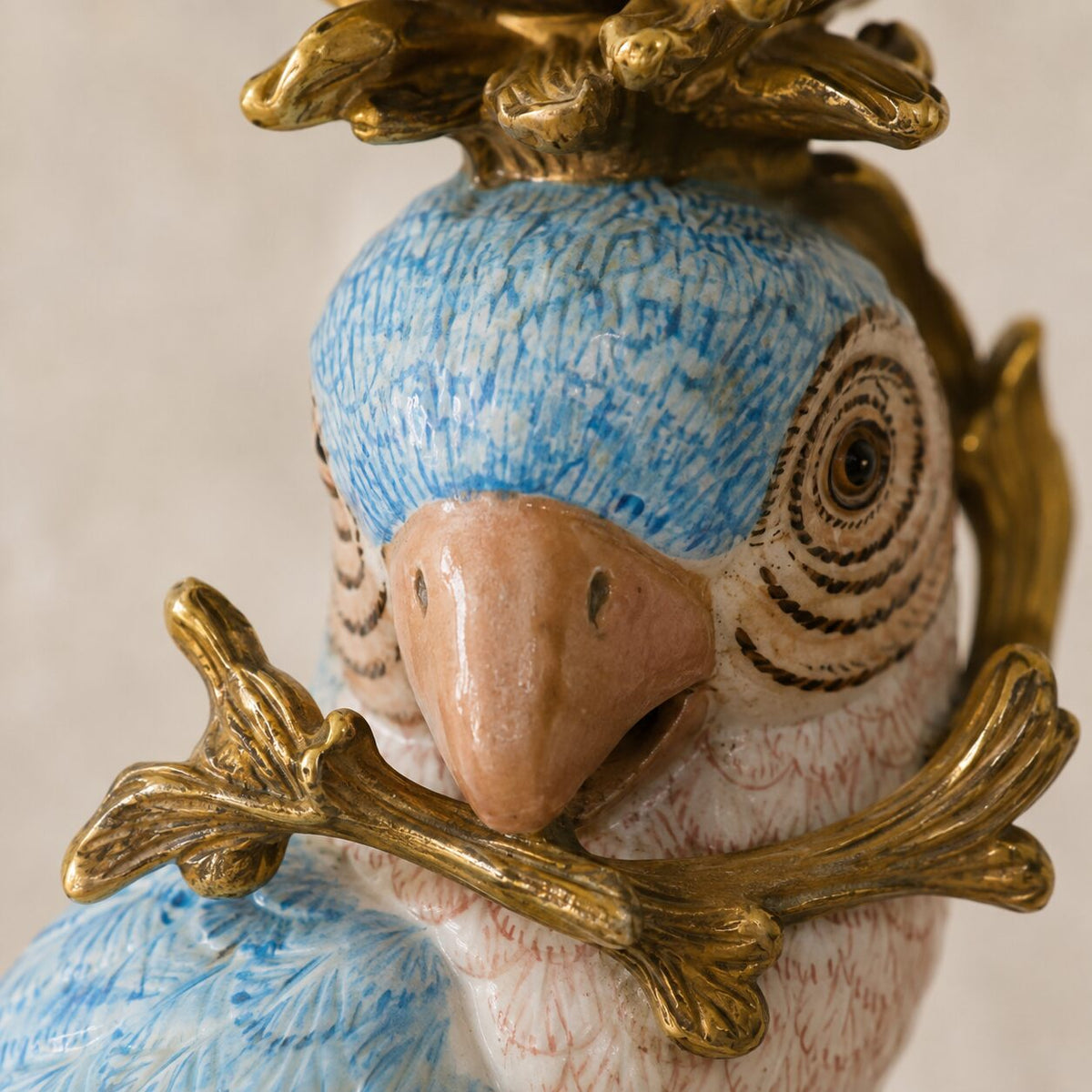 Paire de bougeoirs perroquets en porcelaine et bronze doré, détail tête perroquet