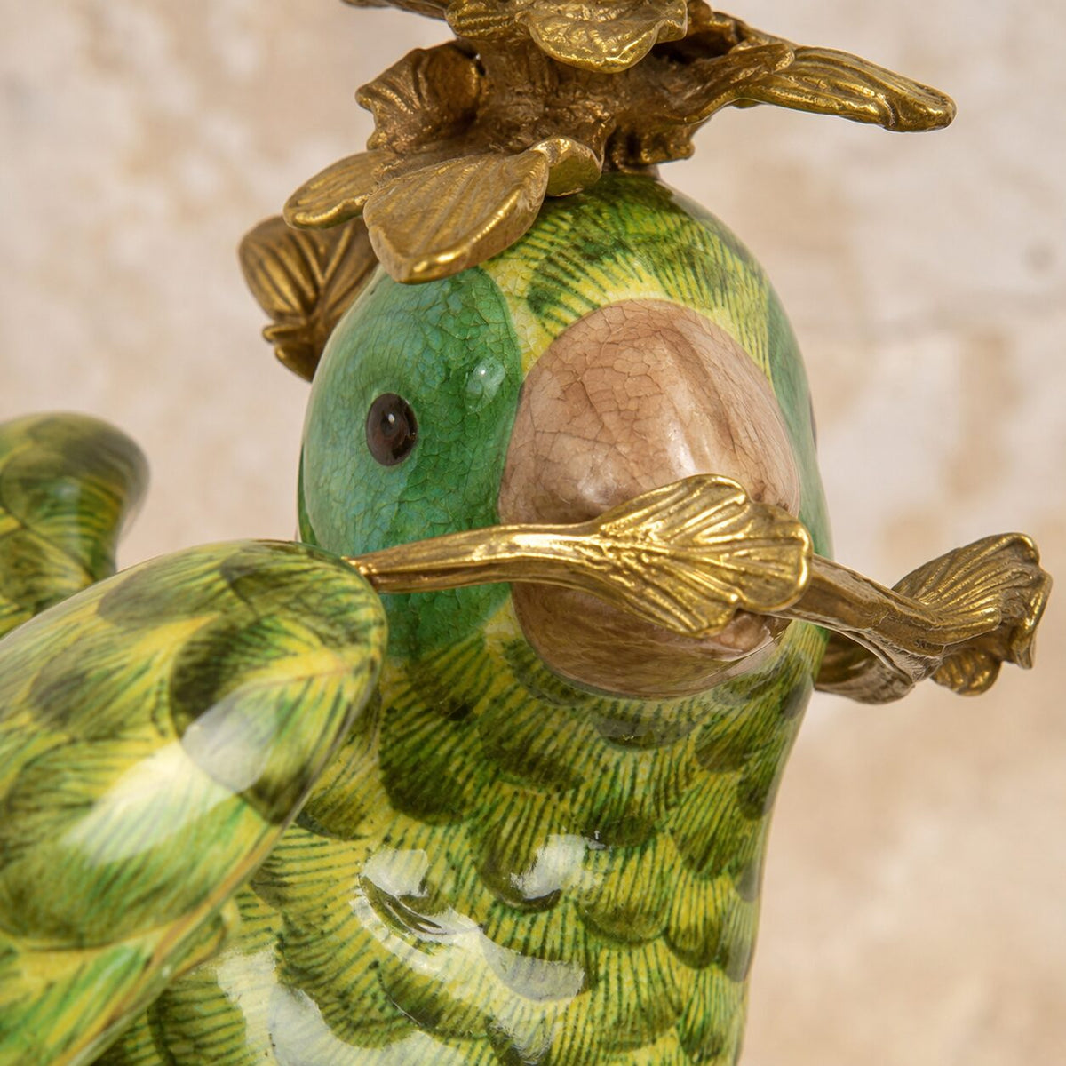 Paire de bougeoirs perroquets en porcelaine et bronze doré, détail tête branche
