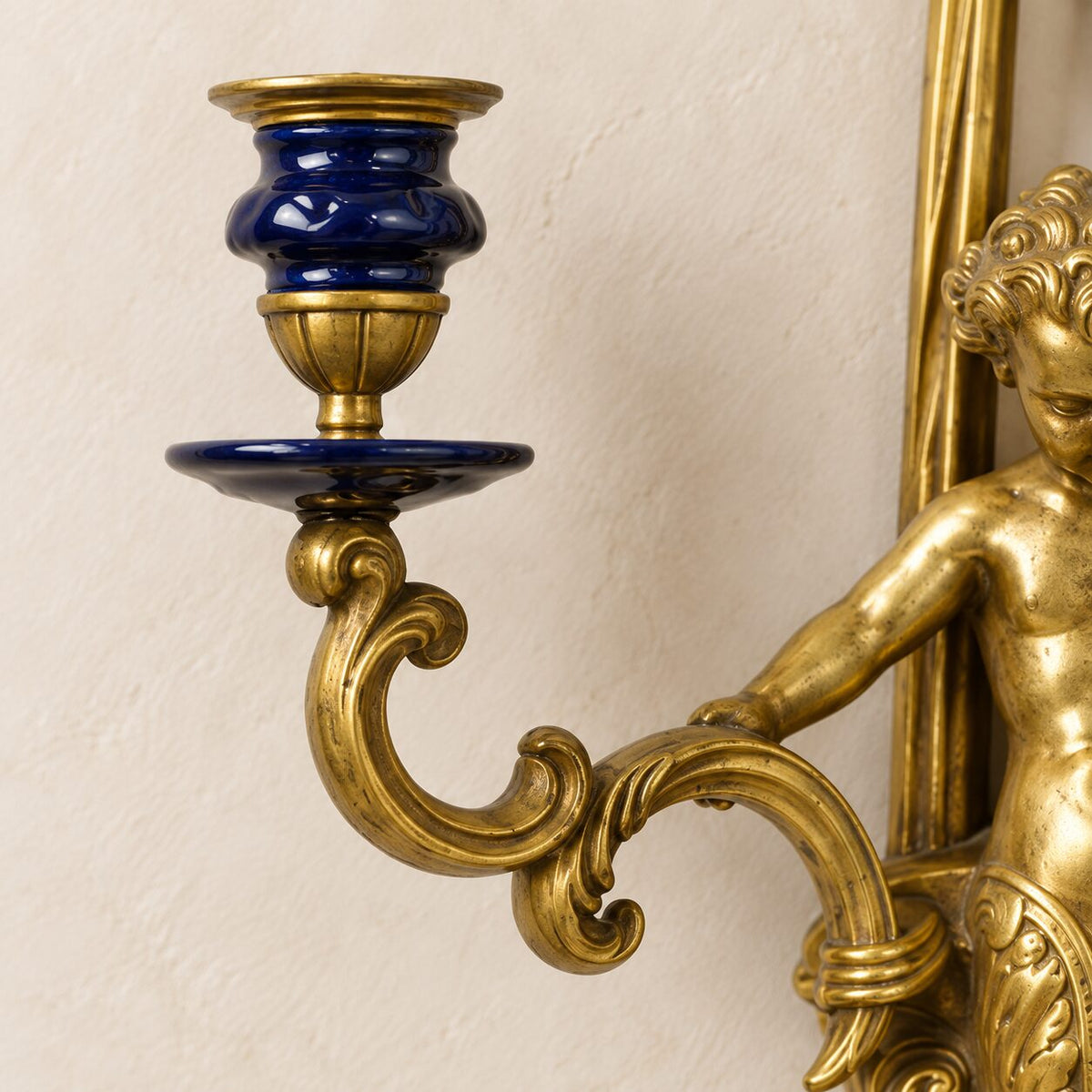 Applique murale au putto en bronze doré et porcelaine bleue, détail bougeoir porcelaine bleue gros plan