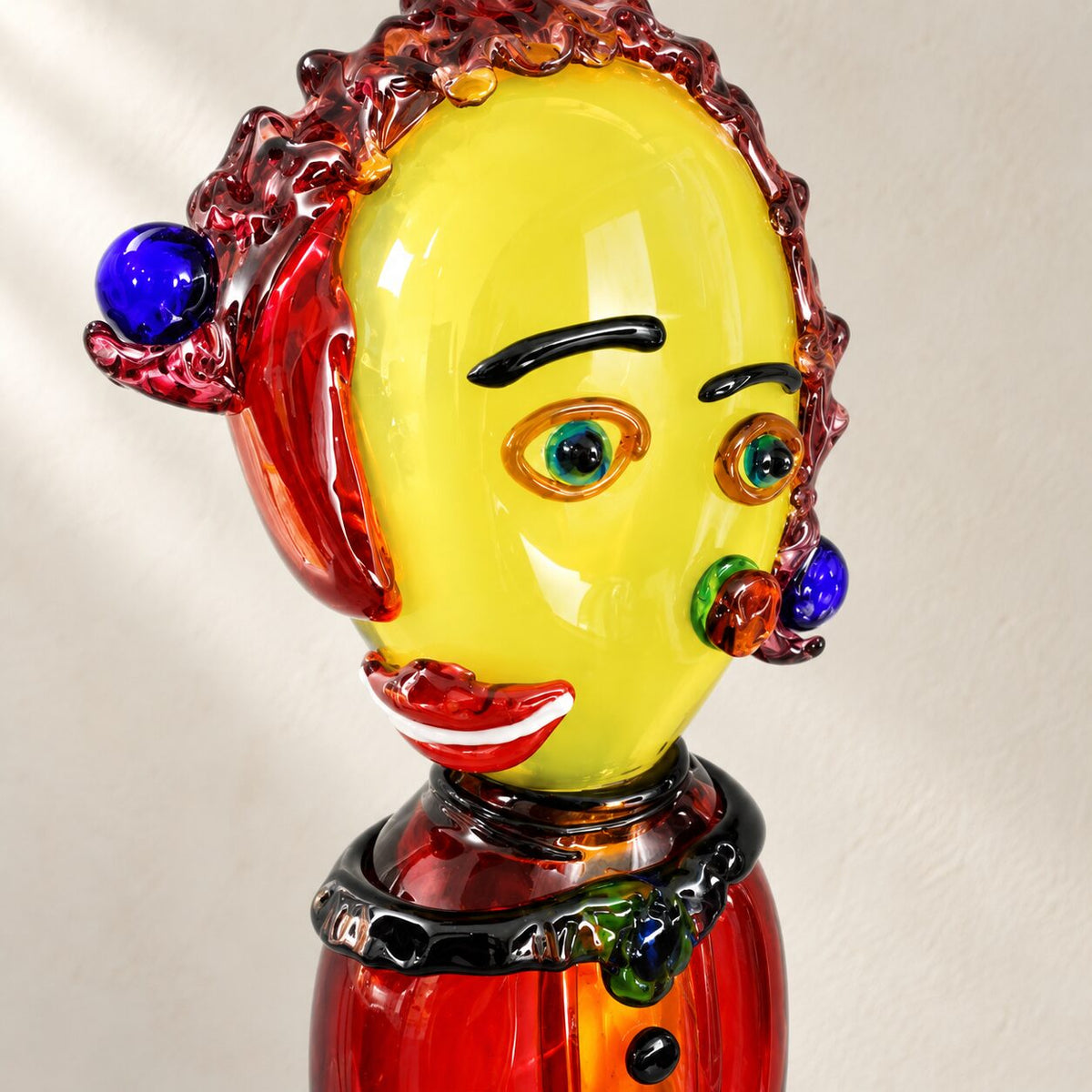 Buste de clown en verre soufflé polychrome, détail du visage et de l'oreille bleue