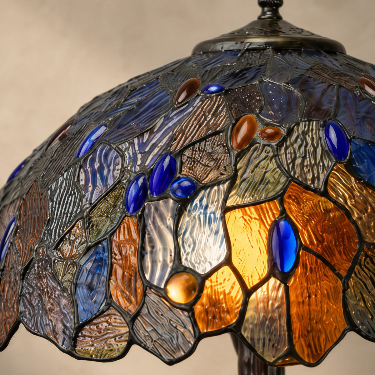Lampe de style Tiffany à décor de feuillages bleus et ambrés, zoom vitrail fleuron allumé