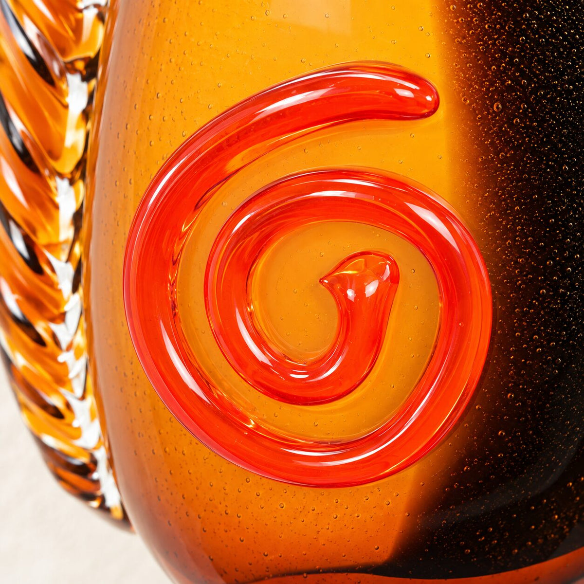 Vase visage abstrait en verre style Murano orange et noir, détail spirale rouge gros plan