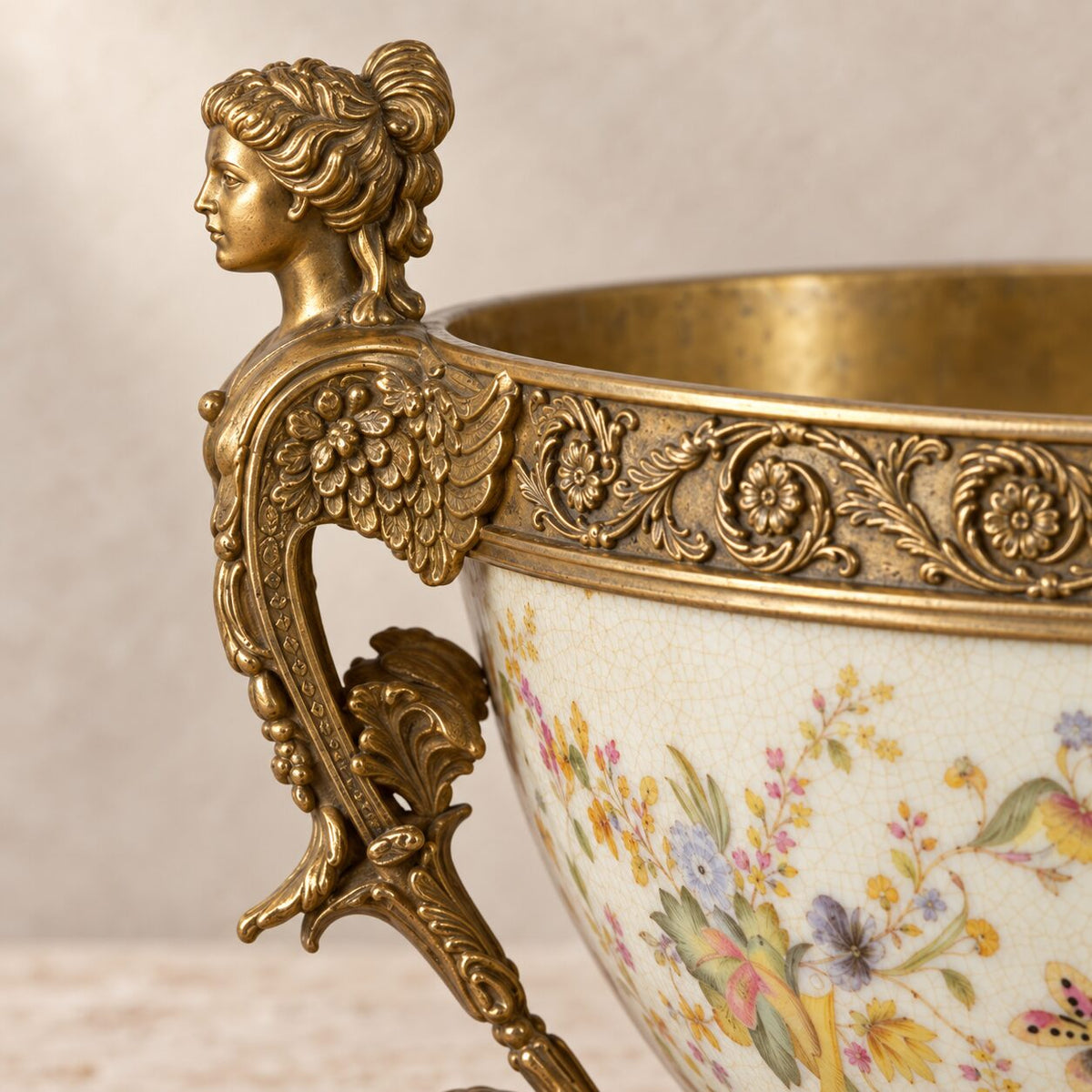 Coupe en porcelaine craquelée à décor floral, monture bronze, détail visage cariatide