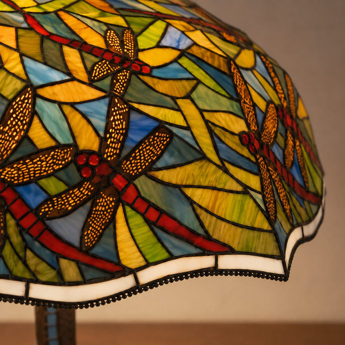 Lampe de style Tiffany aux libellules sur fond de feuillage, gros plan ailes dorées