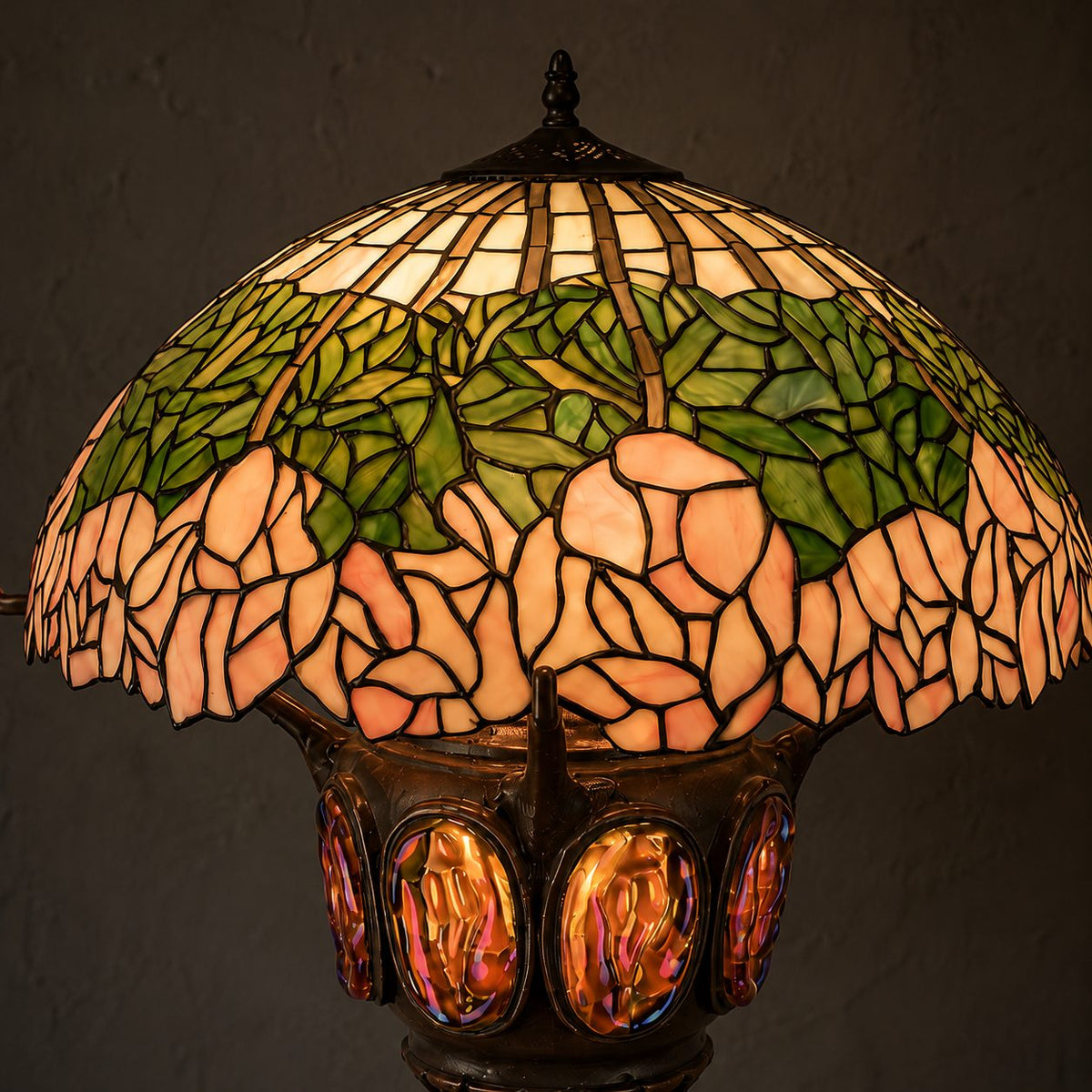 Lampe de style Tiffany aux pivoines roses et pied à cabochons, gros plan vitrail nocturne