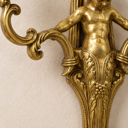 Applique murale au putto en bronze doré et porcelaine bleue, détail pied feuillage bas gros plan