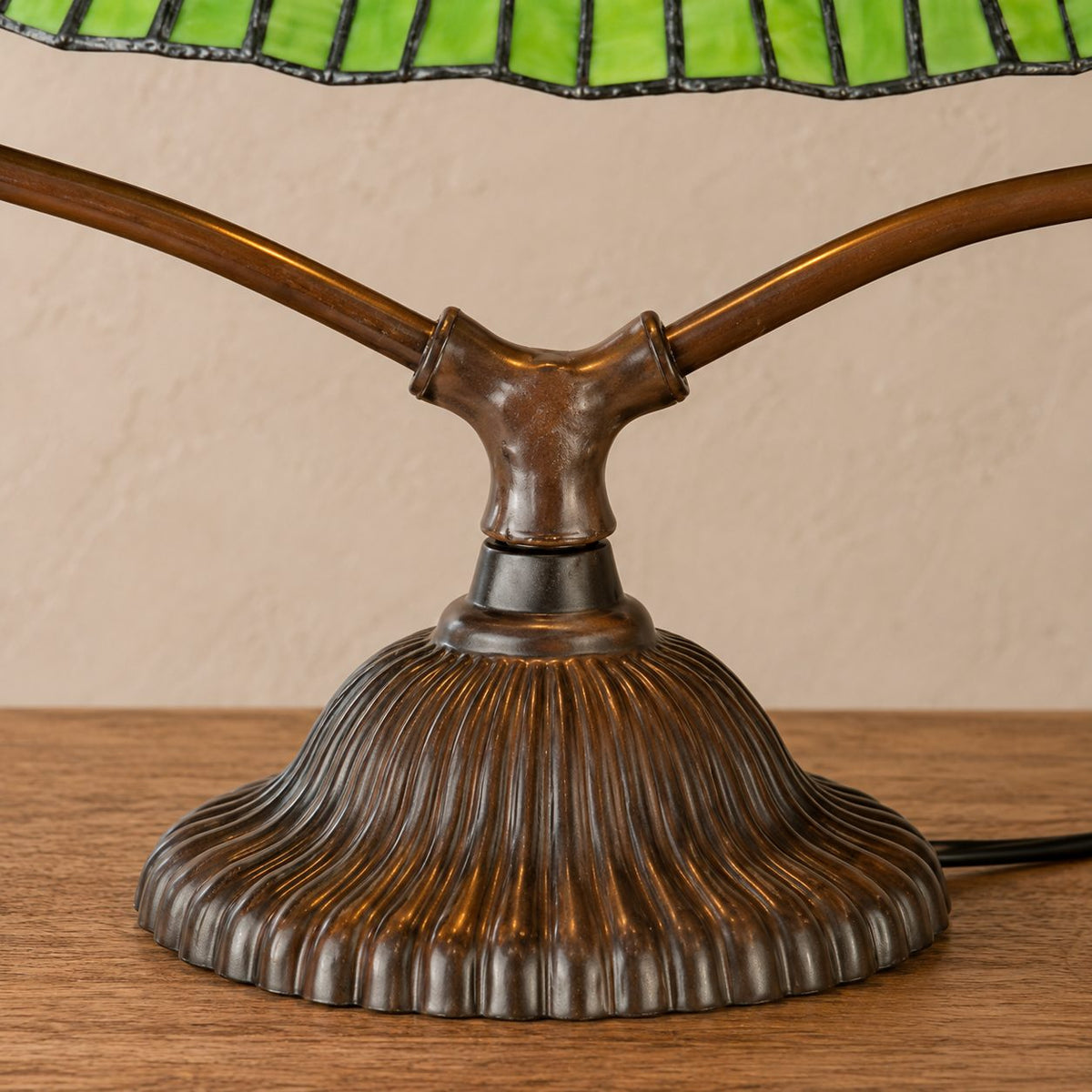 Lampe de style Tiffany, détail du pied cannelé et de la jonction des bras en métal, cordon visible