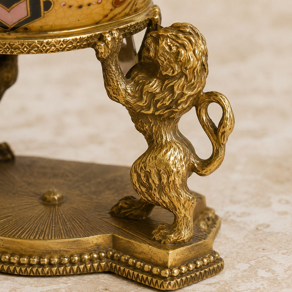 Œuf couvert en porcelaine craquelée jaune sur base lions, détail lion profil