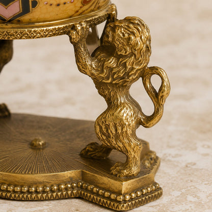 Œuf couvert en porcelaine craquelée jaune sur base lions, détail lion profil