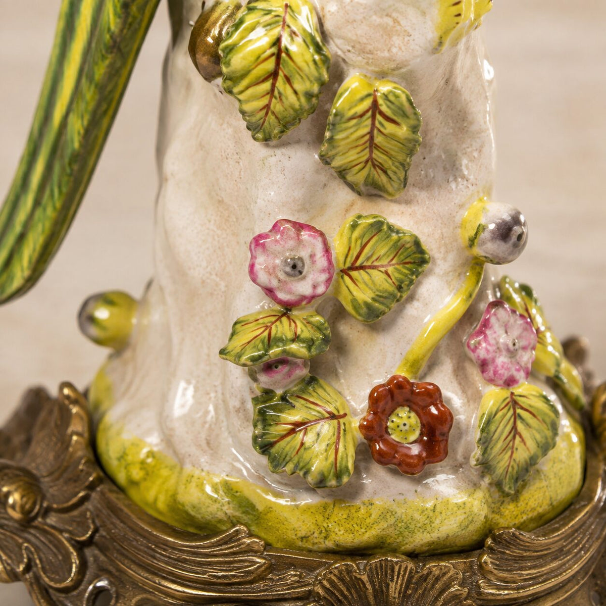 Paire de bougeoirs perroquets en porcelaine et bronze doré, détail tronc fleurs