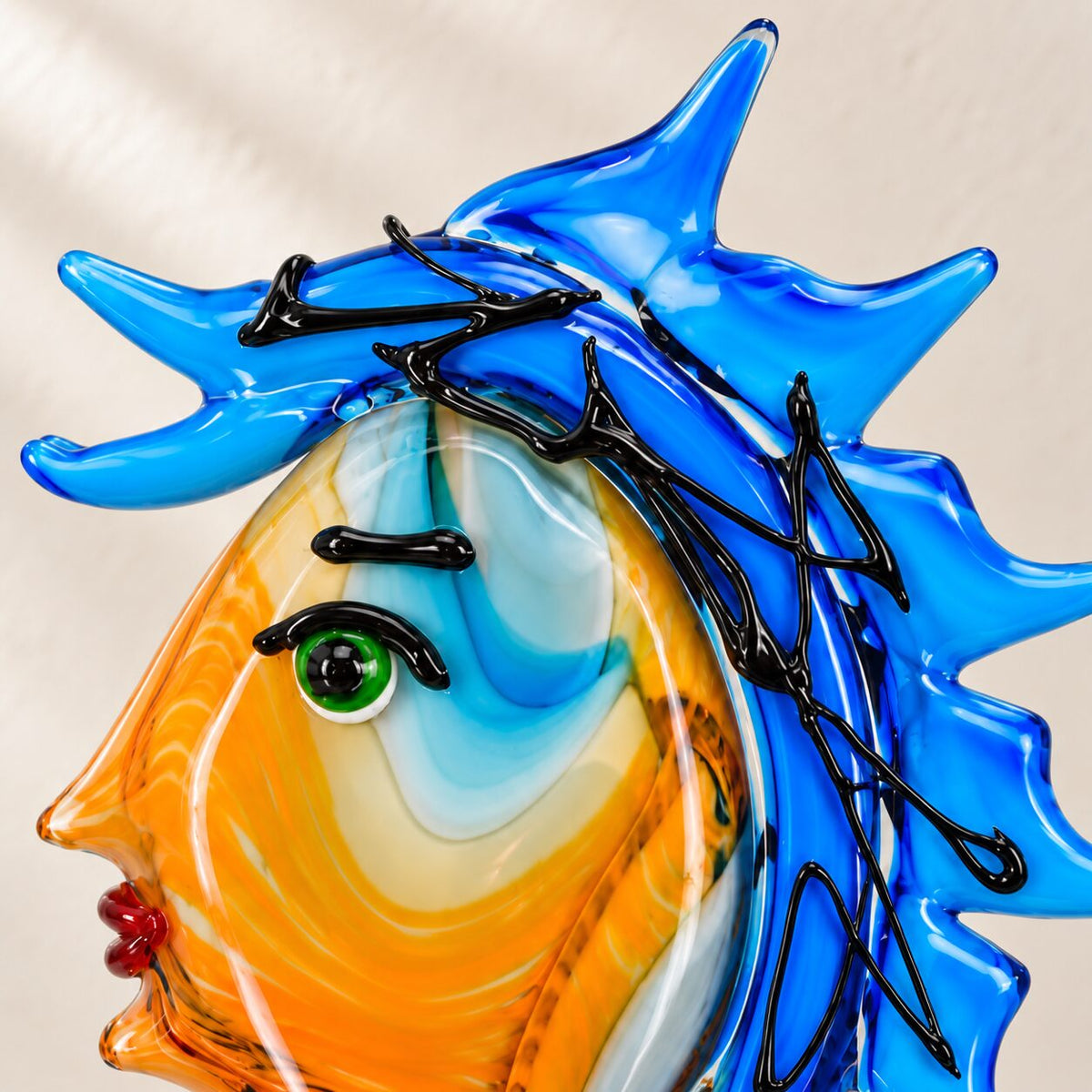 Visage féminin stylisé en verre soufflé bleu cobalt, vue d'ensemble en contre-jour