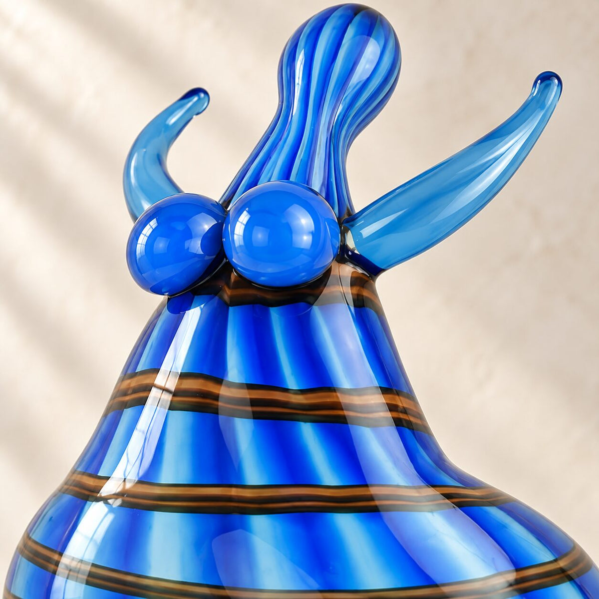 Sculpture danseuse en verre soufflé bleu style Murano, détail tête cornes gros plan