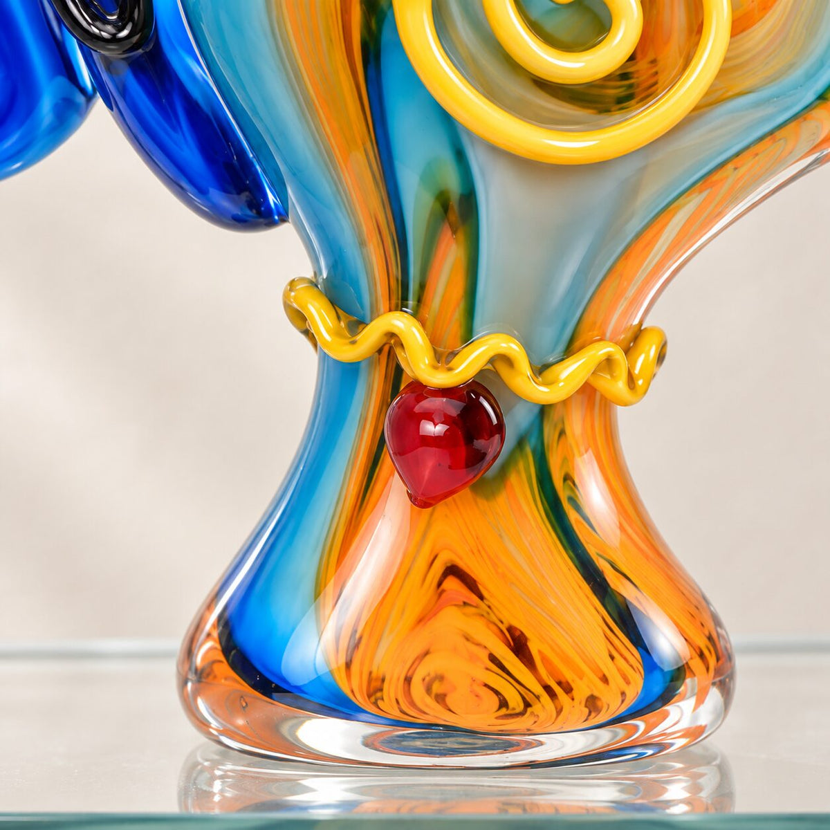 Visage féminin stylisé en verre soufflé bleu cobalt, détail de la base et du collier