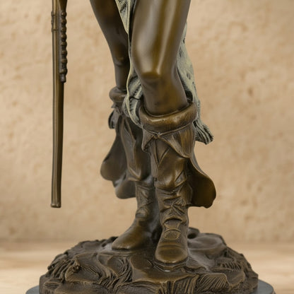 Détail des jambes et bottes en bronze d'une sculpture représentant un chef indien avec fusil