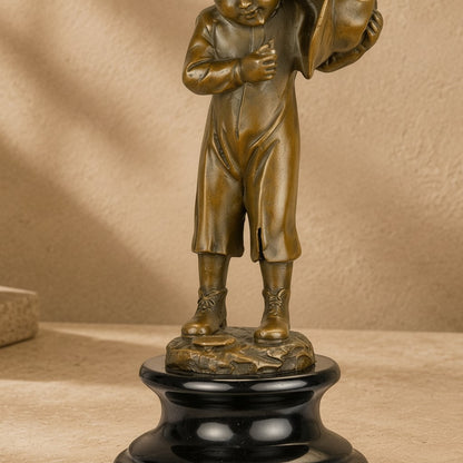 Sculpture en bronze patiné représentant un enfant porteur de hotte sur un socle en marbre noir poli