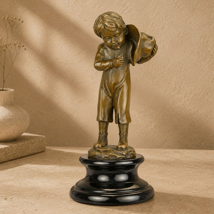 Sculpture en bronze patiné représentant un enfant avec hotte sur un socle en marbre noir poli