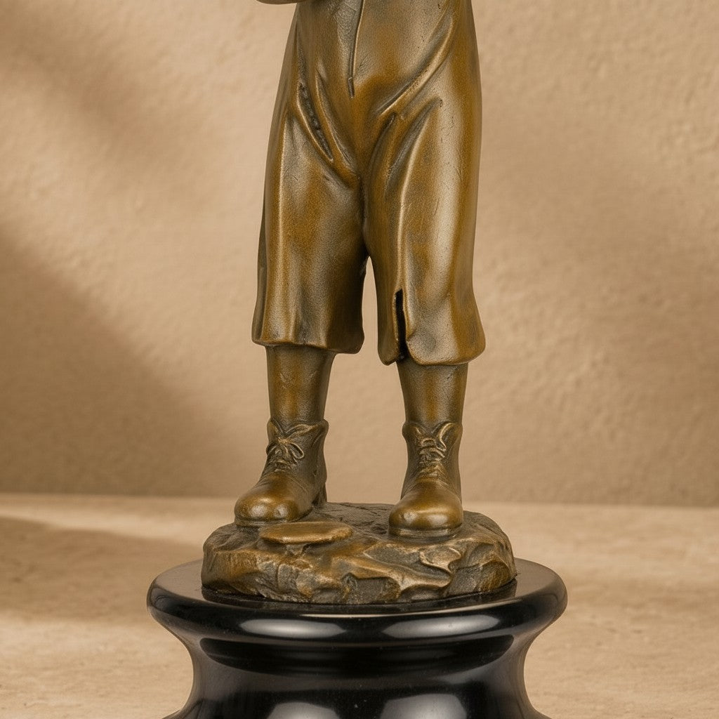 Sculpture en bronze patiné représentant un enfant sur un socle en marbre noir veiné