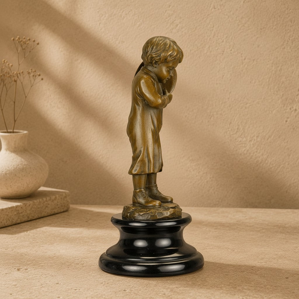 Sculpture en bronze représentant un enfant porteur de hotte sur un socle en marbre noir poli