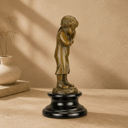Sculpture en bronze représentant un enfant porteur de hotte sur un socle en marbre noir poli