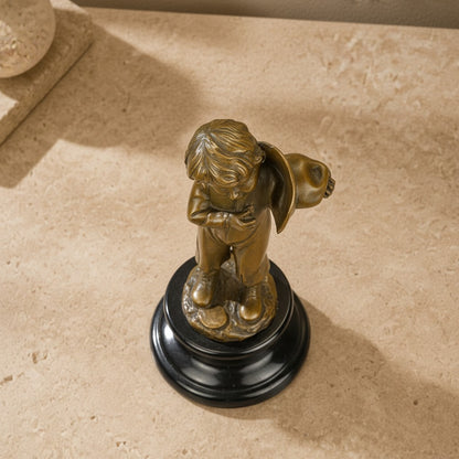 Sculpture en bronze patiné représentant un enfant avec hotte sur socle en marbre noir veiné