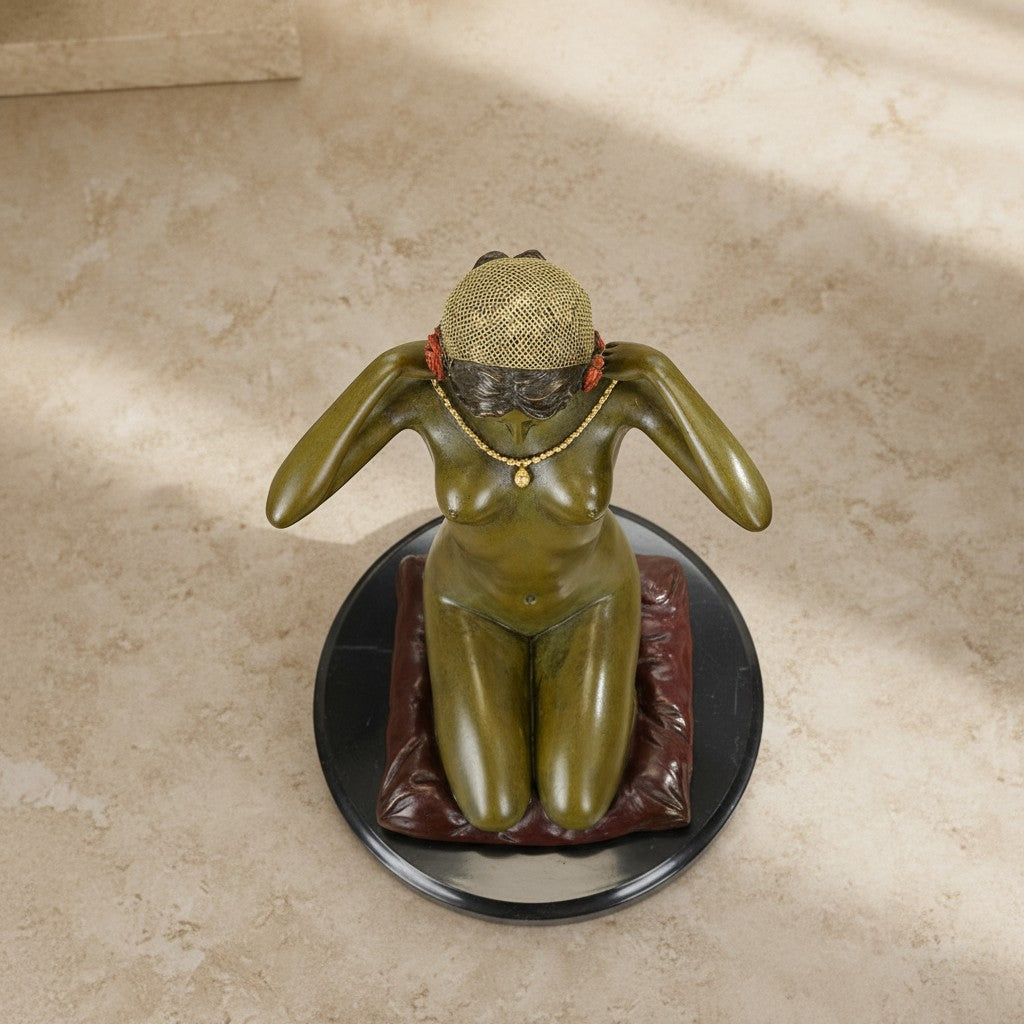 Sculpture en bronze vert-olive représentant une femme agenouillée sur un coussin bordeaux avec collier