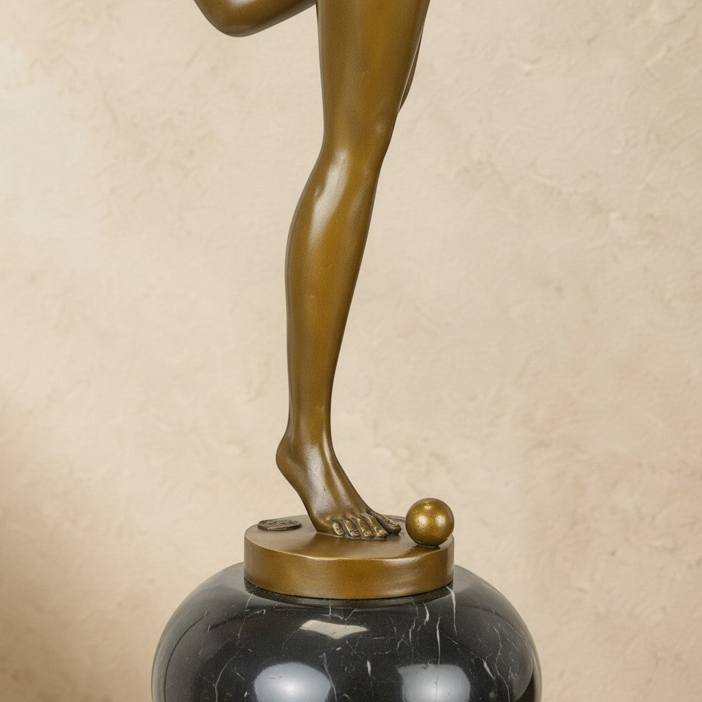 Sculpture en bronze patiné représentant une jongleuse sur un socle en marbre noir veiné