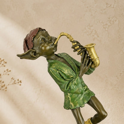 Sculpture en bronze polychrome représentant un lutin jouant du saxophone sur un socle en marbre
