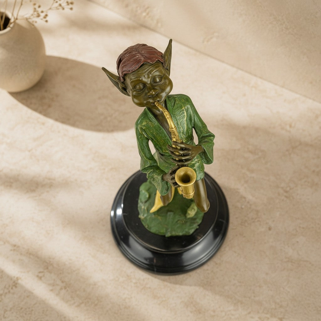 Sculpture en bronze polychrome représentant un lutin jouant du saxophone sur un socle en marbre noir