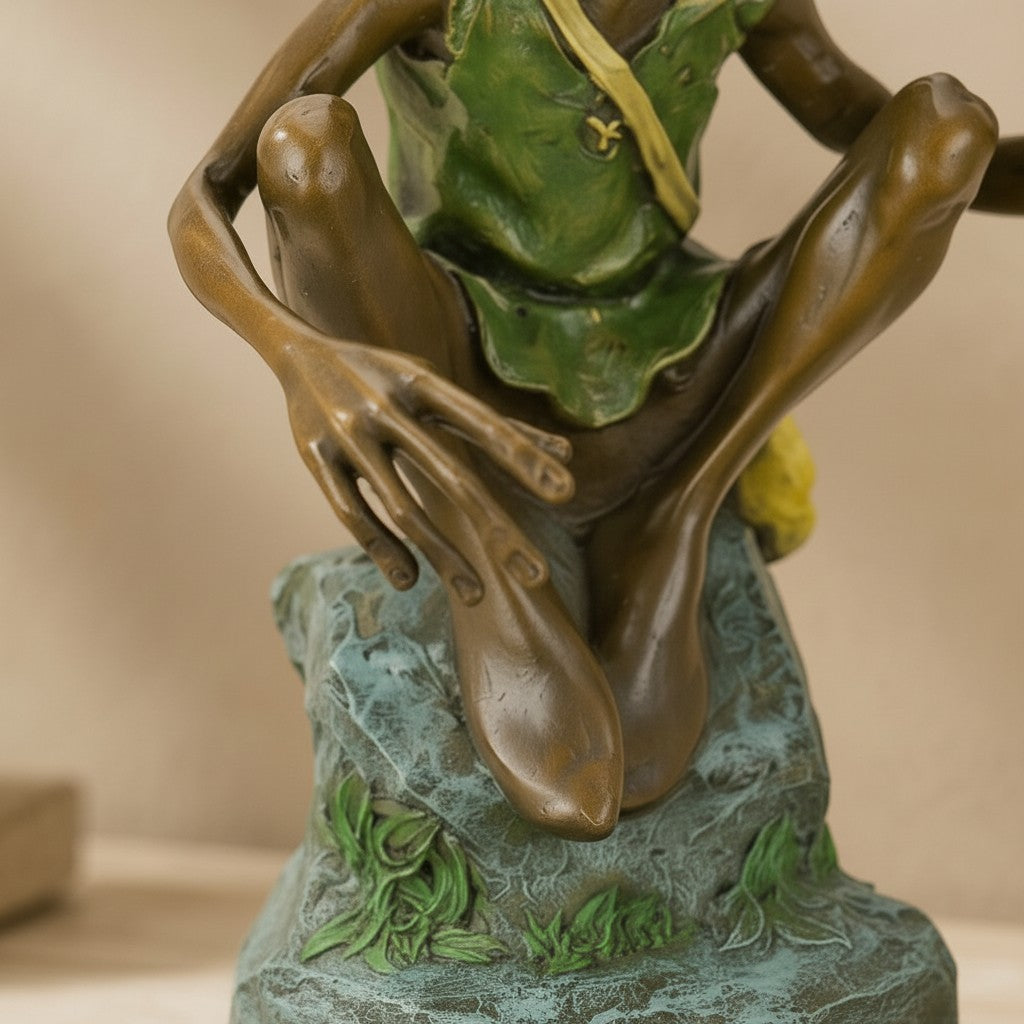 Sculpture en bronze polychrome représentant un lutin rieur en gilet vert assis sur un rocher