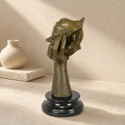 Sculpture en bronze patine brune représentant une tête de lutin songeur sur socle en marbre noir