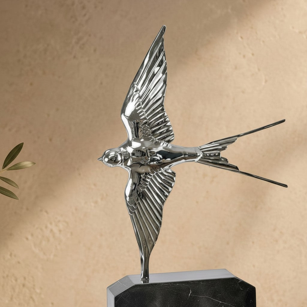 Sculpture d'une hirondelle en bronze argenté aux ailes déployées sur un socle en marbre noir