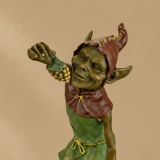 Sculpture en bronze polychrome représentant un lutin espiègle tenant une grappe de raisins dorés