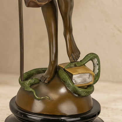 Détail de la statue en bronze représentant Thémis avec un serpent et un livre sur socle en marbre