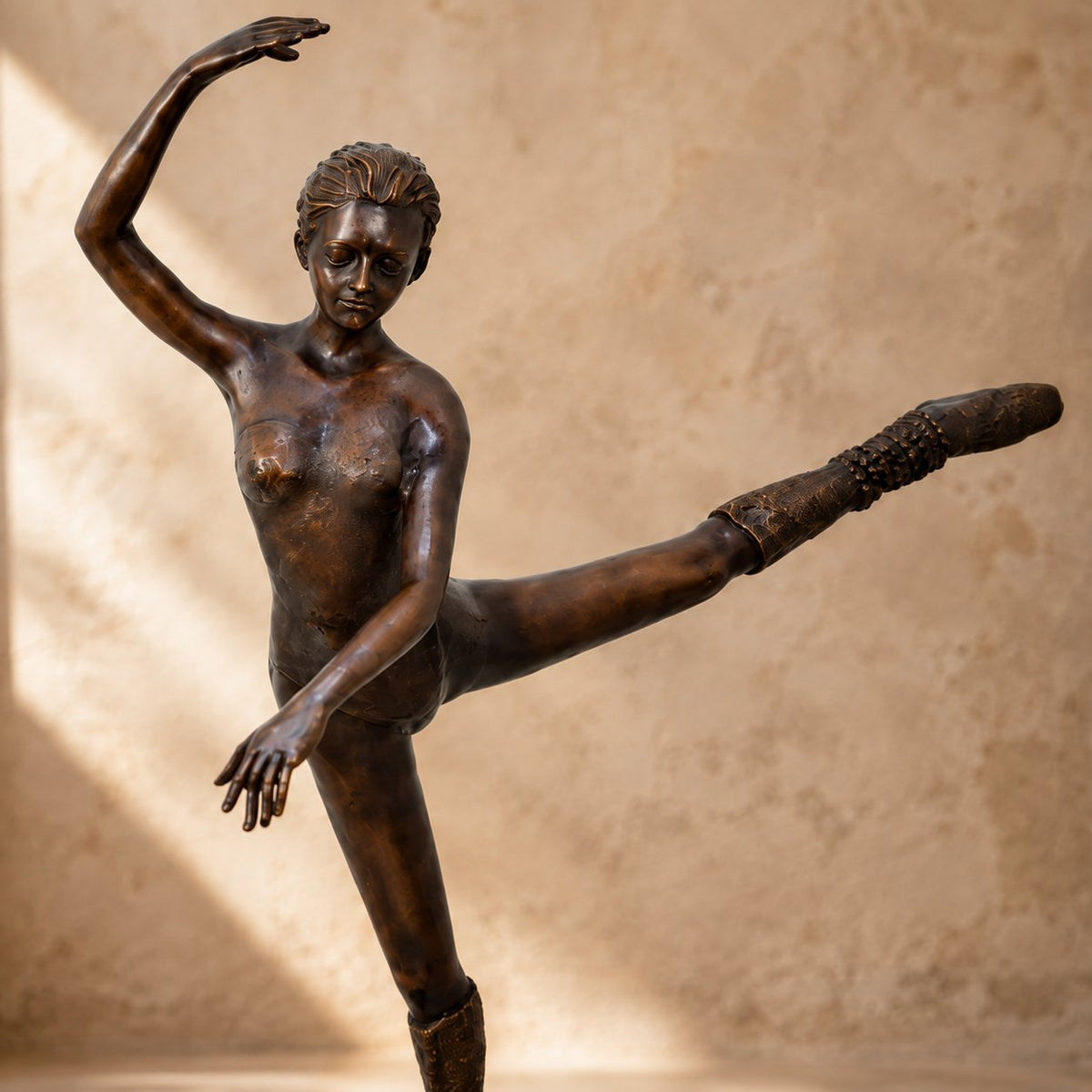 Sculpture bronze danseuse classique en arabesque sur socle, vue rapprochée buste